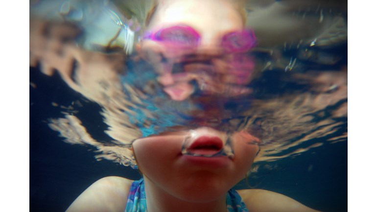 A child swimming underwater.