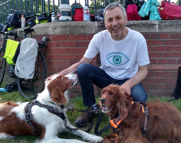 Tim in his Nystagmus Network T shirt with 2 dogs.