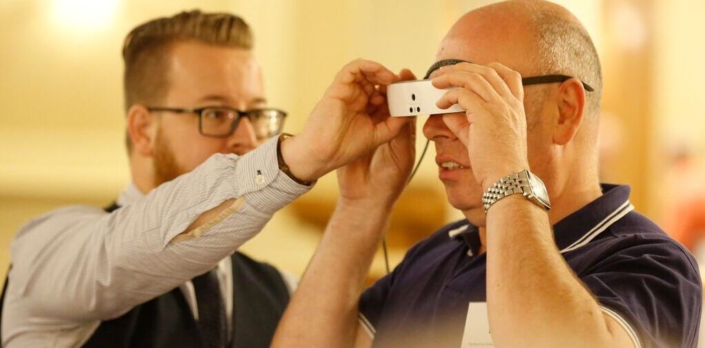 A man is assisted to try out a piece of low vision technology.