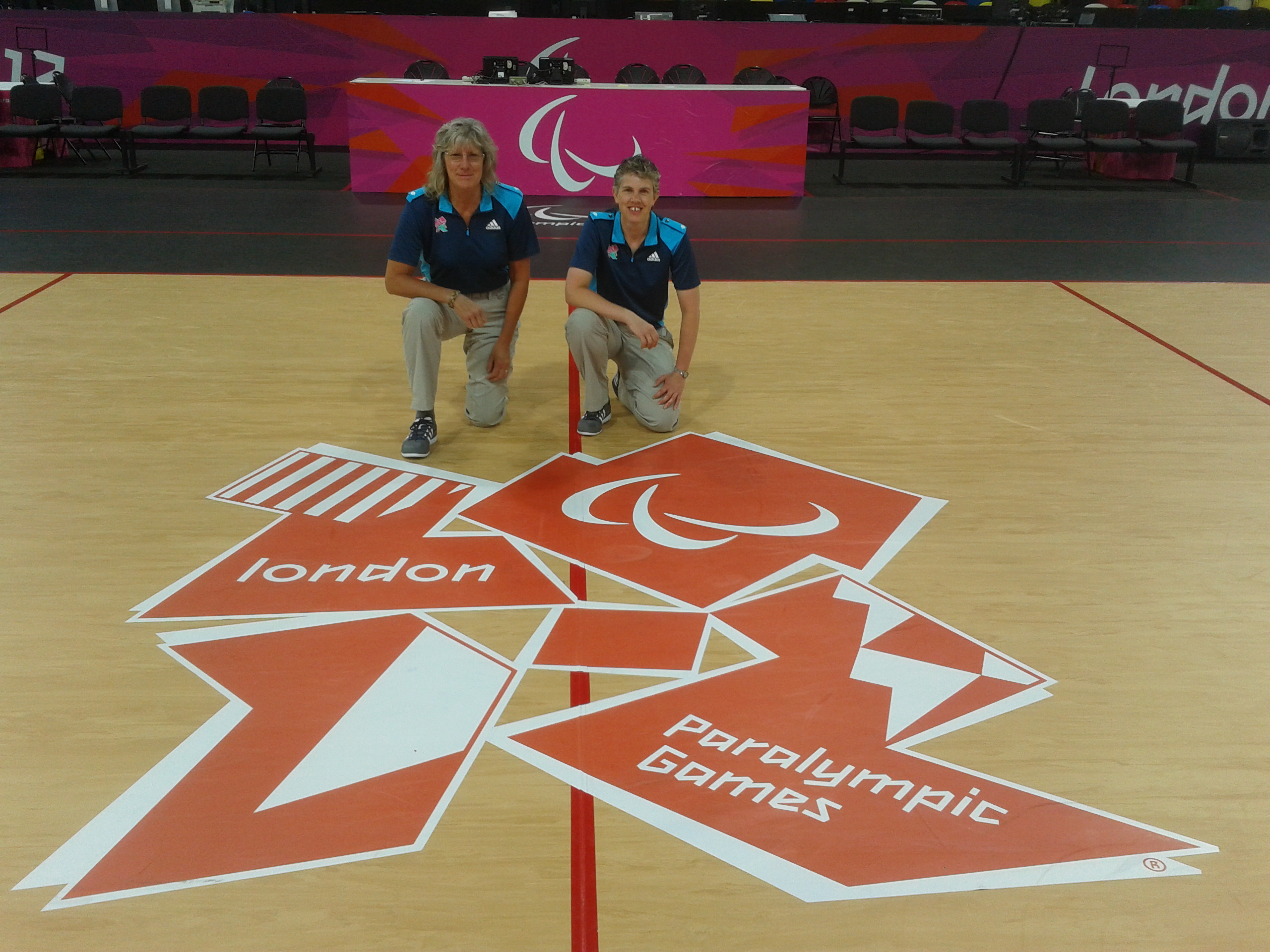 Christine and Kathryn kneel by the London Paralympics emblem.