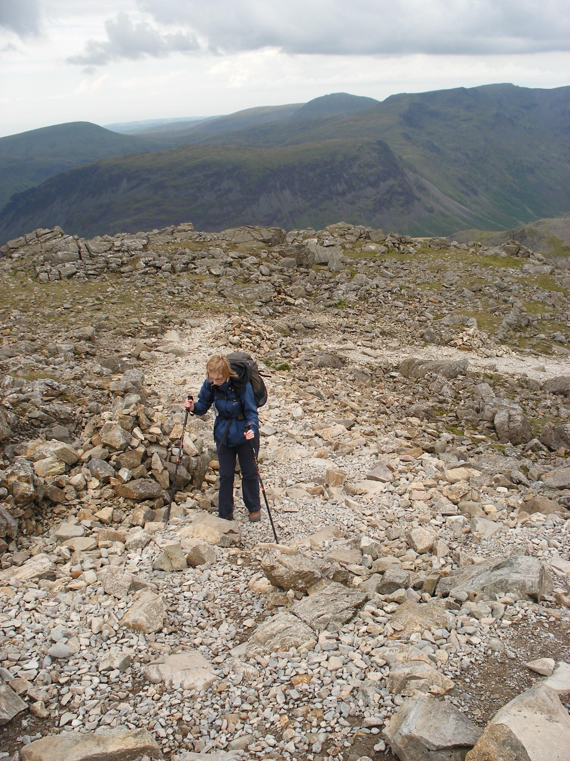 Hanni negotiating a rock with two walking poles on Scafell Pike.