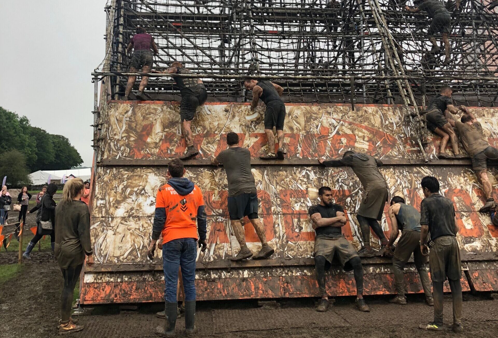 People taking part in a tough mudder climb