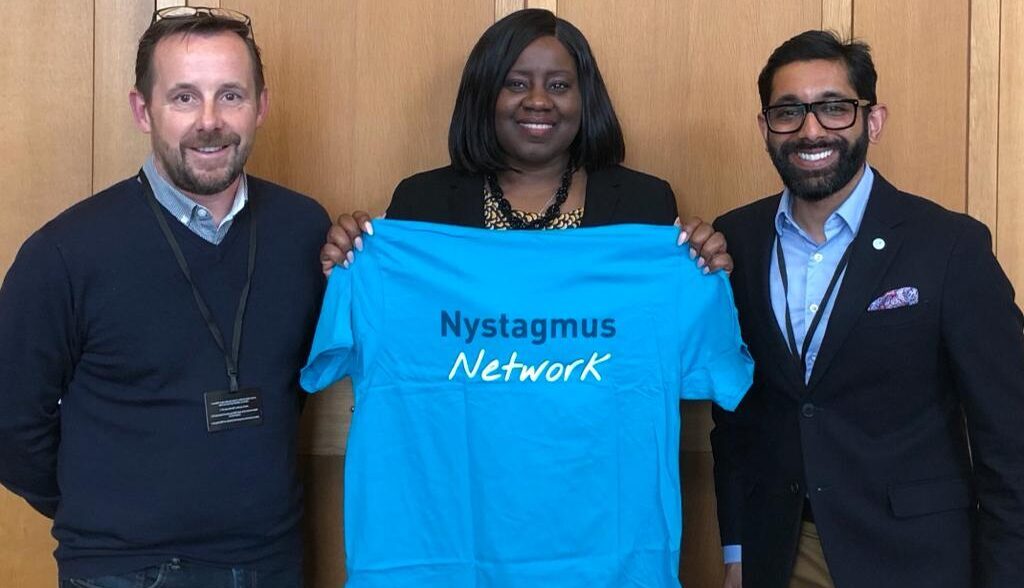 L-R Peter Greenwood, Marsha De Cordova MP (holding Nystagmus Network T-shirt, Harshal Kubavat.