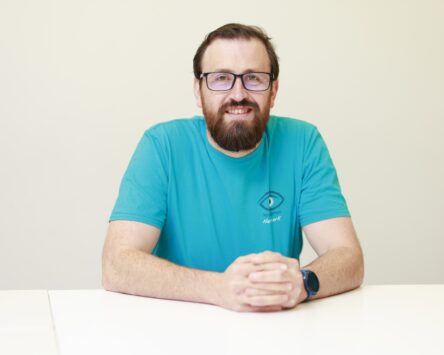 Andy McFarlane wearing a blue Nystagmus Network T-shirt.