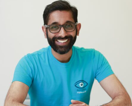 Harshal Kubavat wearing a blue Nystagmus Network T-shirt.