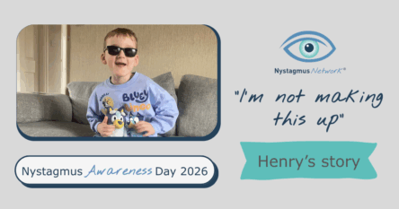 Henry is wearing his dark glasses, sitting on a sofa, holding soft toys.