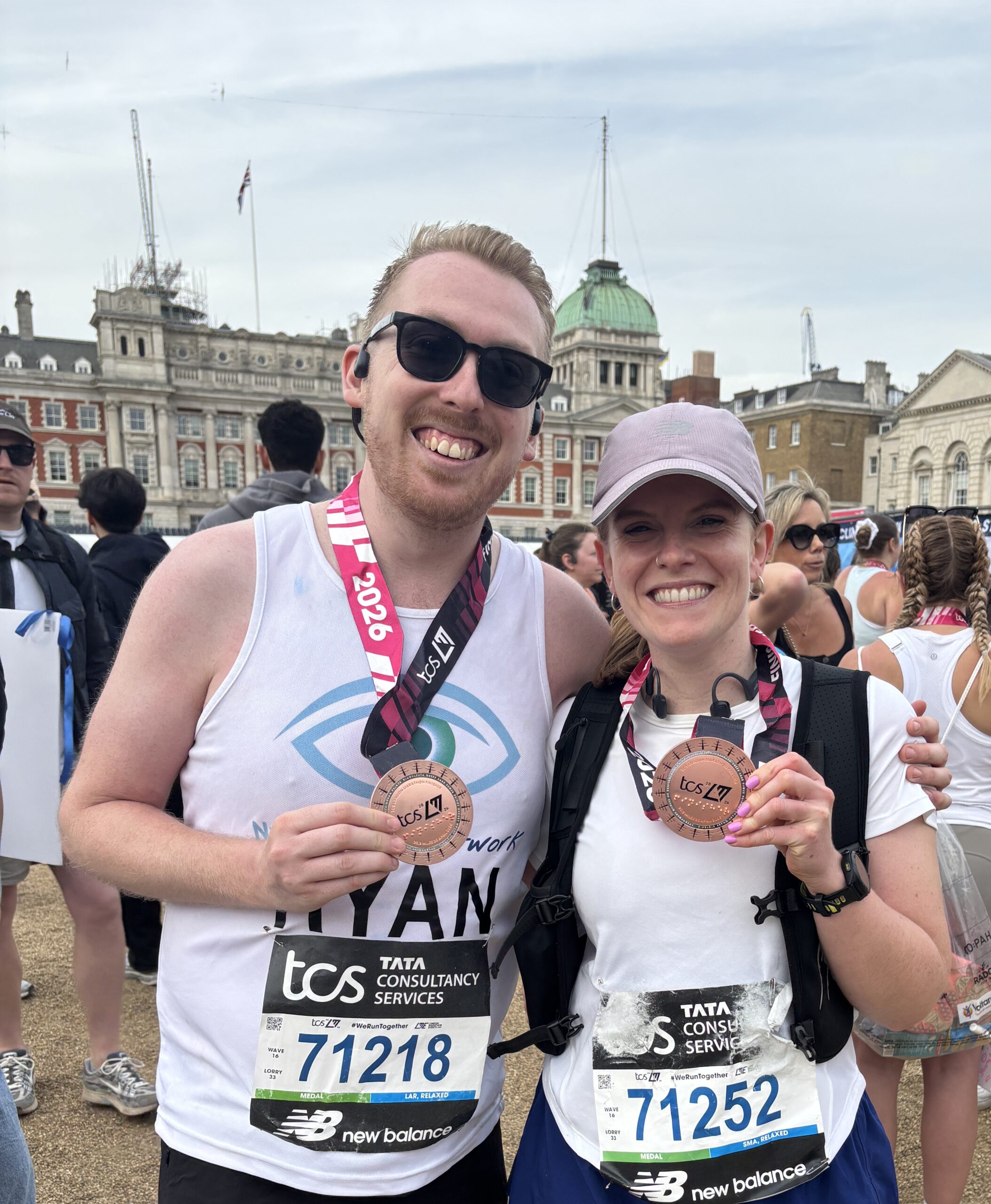 Ryan, wearing his Nystagmus Network running vest and Victoria hold up their finishers' medals.